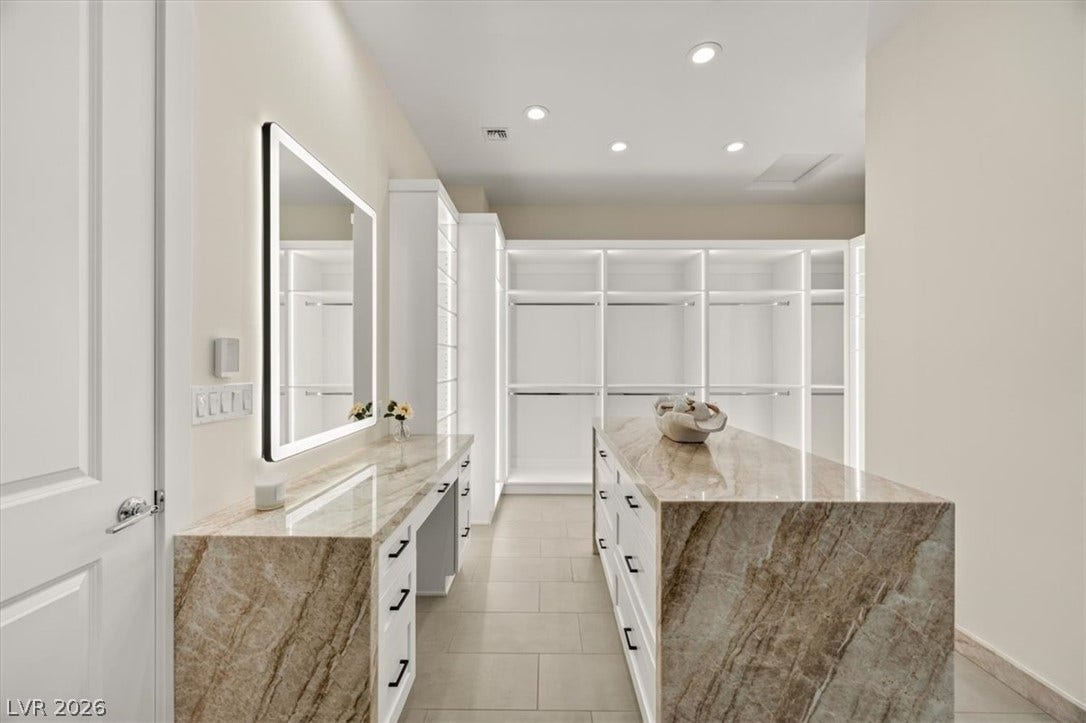 2611 Nevada Agave Lane, Las Vegas, NV 89138 Polished stone surfaces and extensive built-in storage define this customized walk-in closet space.