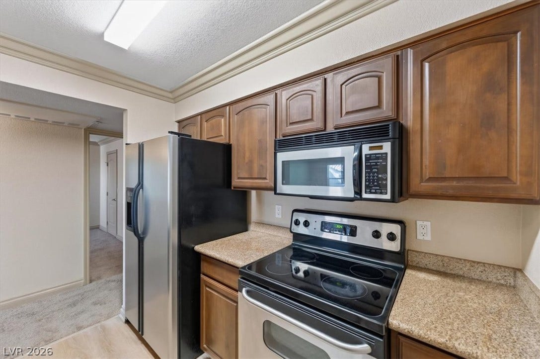 Rich wood cabinetry paired with durable countertops highlights this functional culinary workspace.