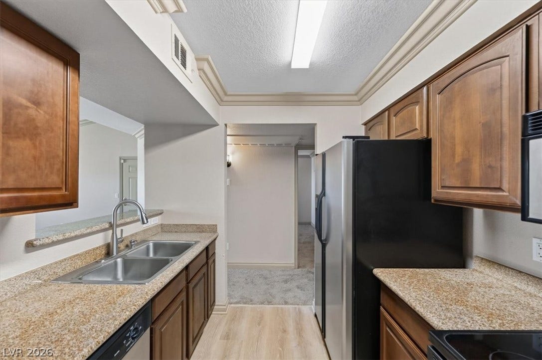 Rich wood cabinetry and stone counters define this classic, functional galley layout.