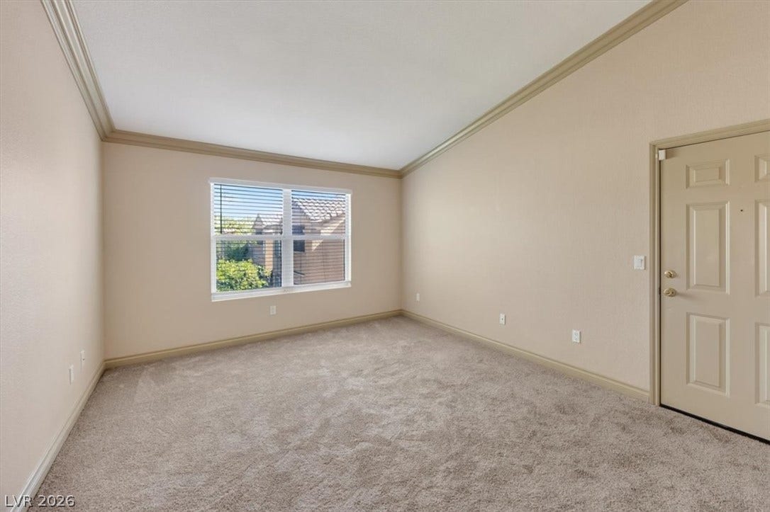 Vaulted ceilings and plush carpeting define this versatile living space.