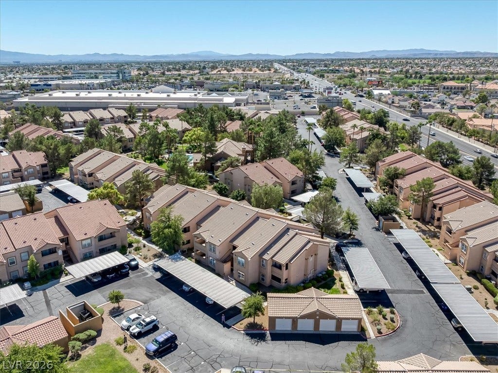 An aerial perspective reveals a structured residential community nestled near convenient thoroughfares and rolling mountain views.