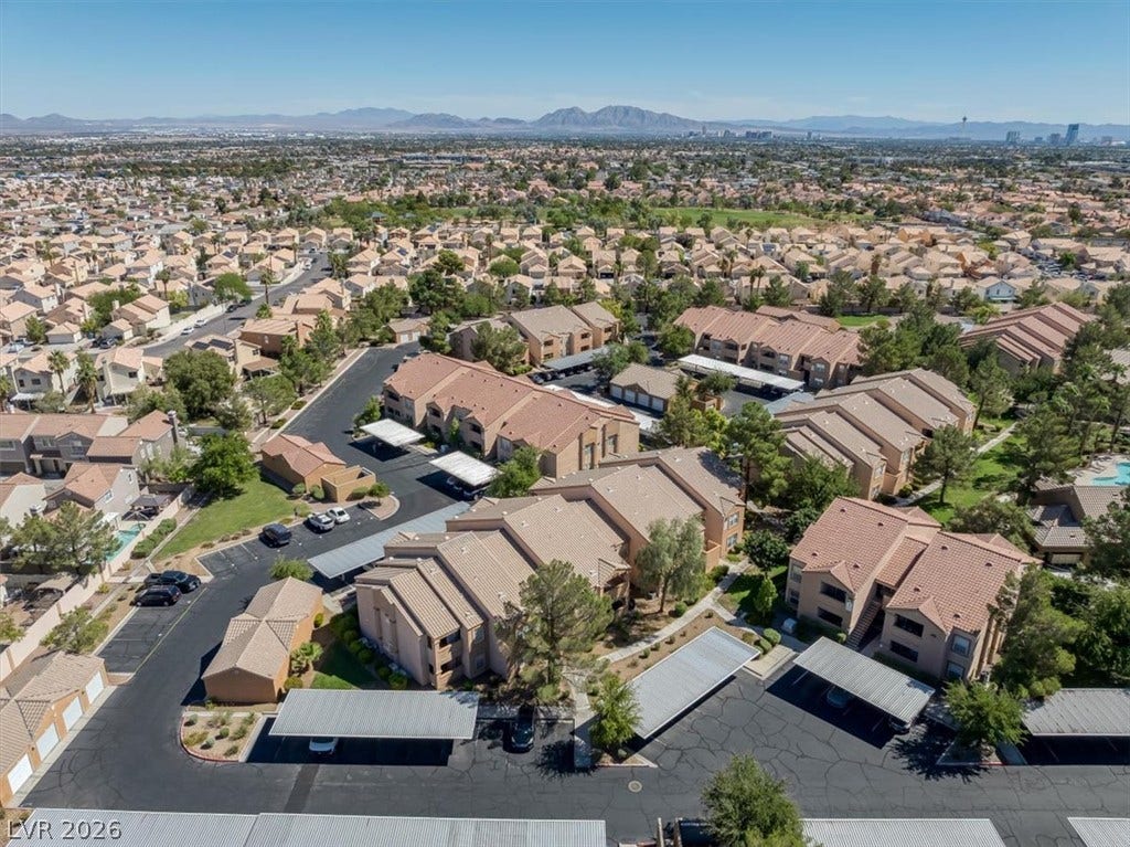 An aerial perspective captures the residential complex set against a distant mountain silhouette.