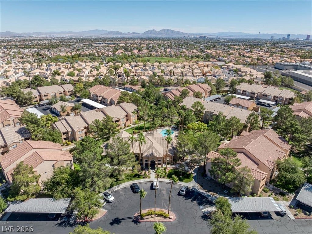 An aerial perspective showcases a quiet residential community nestled against a distant mountain backdrop.