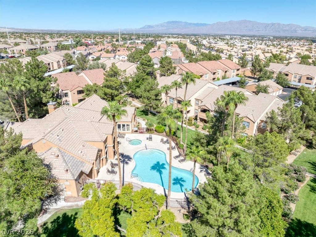 An aerial perspective showcases a sparkling community pool nestled among manicured lawns and mature trees.