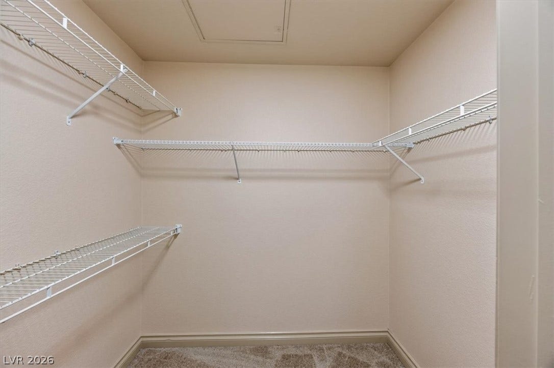 Ample built-in wire shelving highlights this functional closet space completed by neutral carpeting.