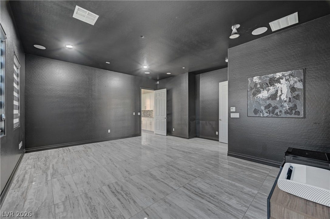 89 Olympia Chase Drive, Las Vegas, NV 89141 Polished tile flooring and dark walls create a dramatic architectural backdrop in this versatile space.
