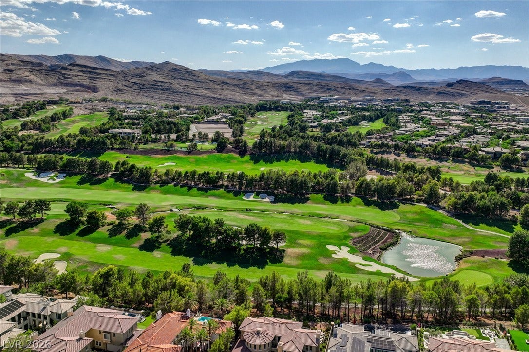 89 Olympia Chase Drive, Las Vegas, NV 89141 Dramatic mountain ranges frame a verdant golf course landscape dotted with mature trees.