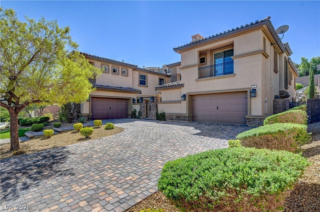 89 Olympia Chase Drive, Las Vegas, NV 89141 An elegant paved driveway leads to the multi-car garages of this handsome stucco home.