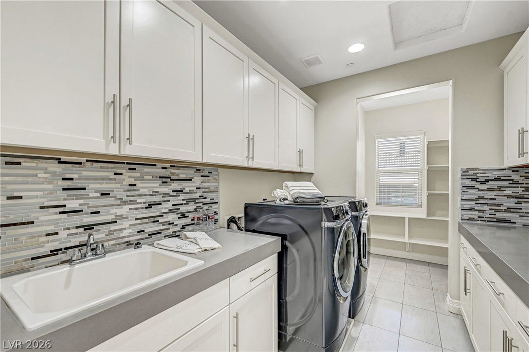 89 Olympia Chase Drive, Las Vegas, NV 89141 A spacious utility room offers modern cabinetry, built-in shelving, and a deep wash sink.