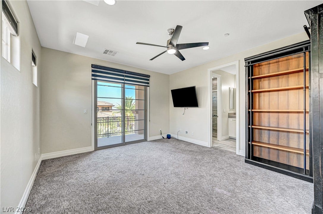 89 Olympia Chase Drive, Las Vegas, NV 89141 Sliding glass doors open to a private balcony in this comfortable carpeted room.