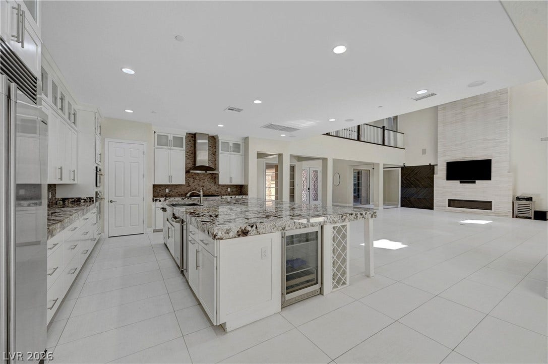 89 Olympia Chase Drive, Las Vegas, NV 89141 Polished tile flooring flows seamlessly from the culinary center to the towering living area.