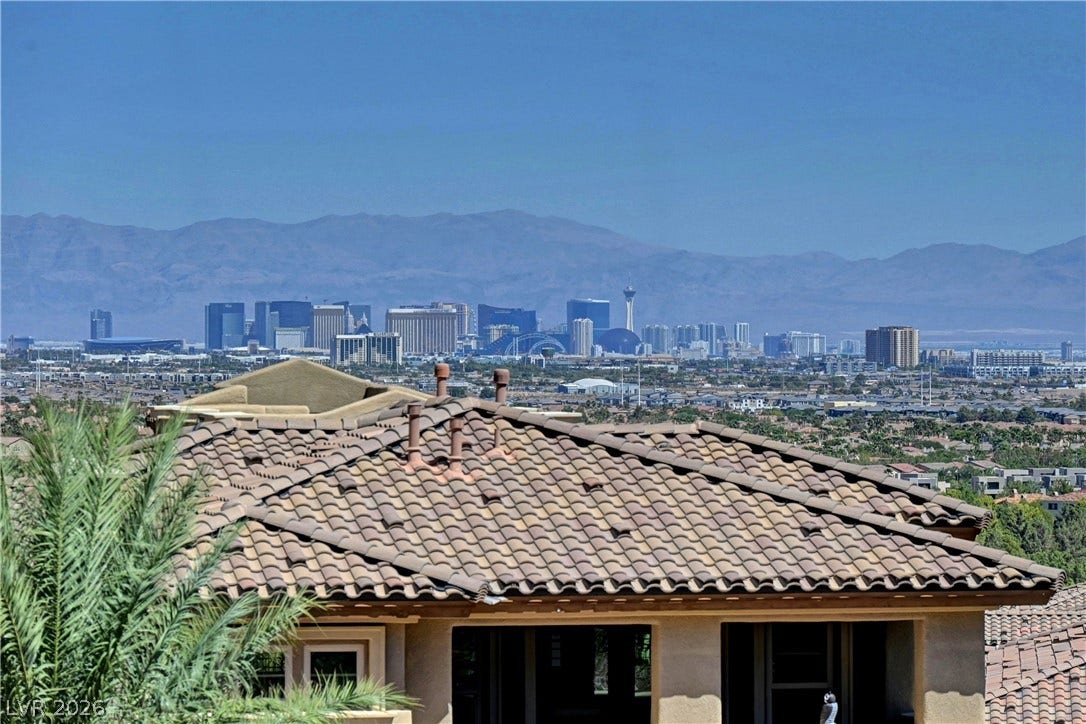 89 Olympia Chase Drive, Las Vegas, NV 89141 Distant city skyline and rugged mountain silhouettes create a dramatic backdrop.