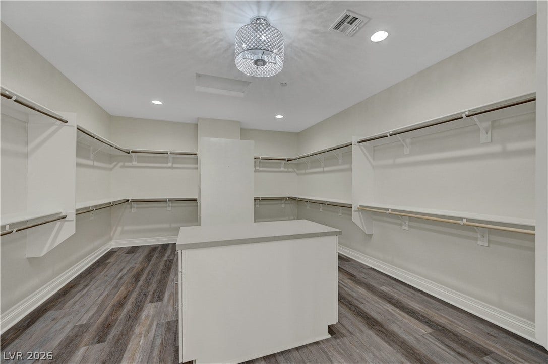 89 Olympia Chase Drive, Las Vegas, NV 89141 Ample hanging rods and a central island maximize storage space in this closet.