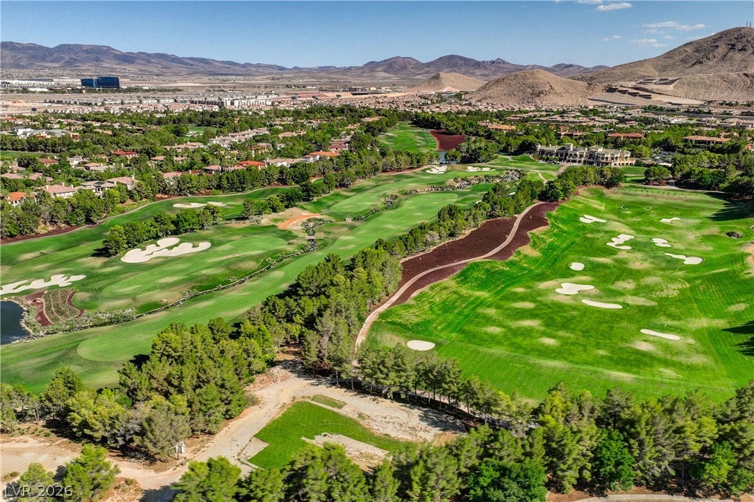 89 Olympia Chase Drive, Las Vegas, NV 89141 Rolling golf course fairways stretch toward desert mountains under a clear blue sky.