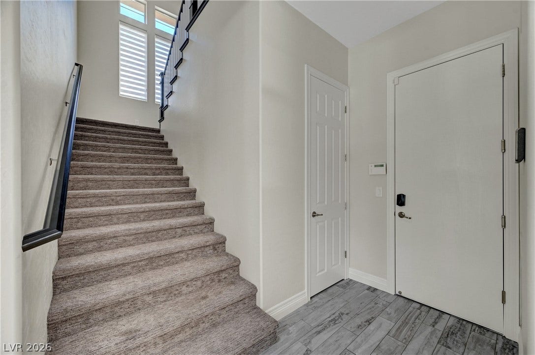 89 Olympia Chase Drive, Las Vegas, NV 89141 An inviting entryway leads directly to carpeted stairs and features durable tile flooring.