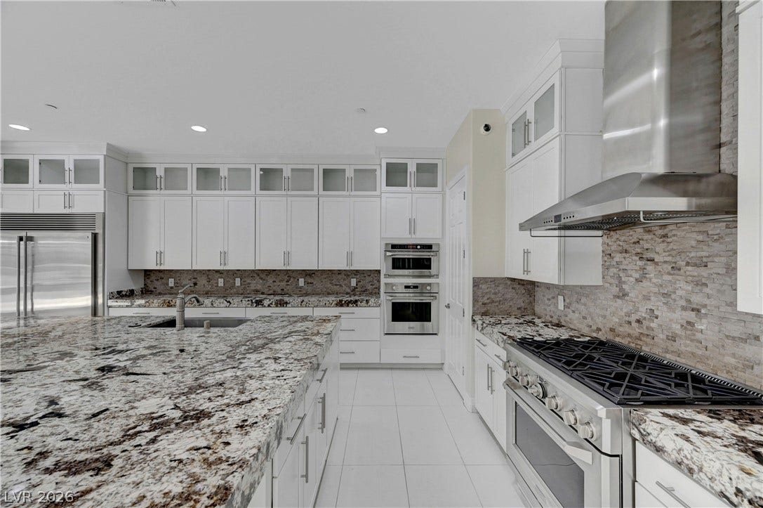 89 Olympia Chase Drive, Las Vegas, NV 89141 Polished granite countertops anchor this kitchen designed with ample cabinetry and high-end stainless steel appliances.