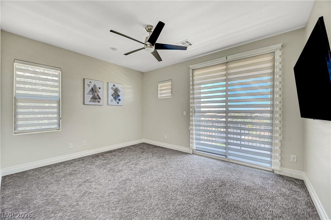 89 Olympia Chase Drive, Las Vegas, NV 89141 Plush carpeting and a sliding glass door lead to the outdoors from this bedroom.
