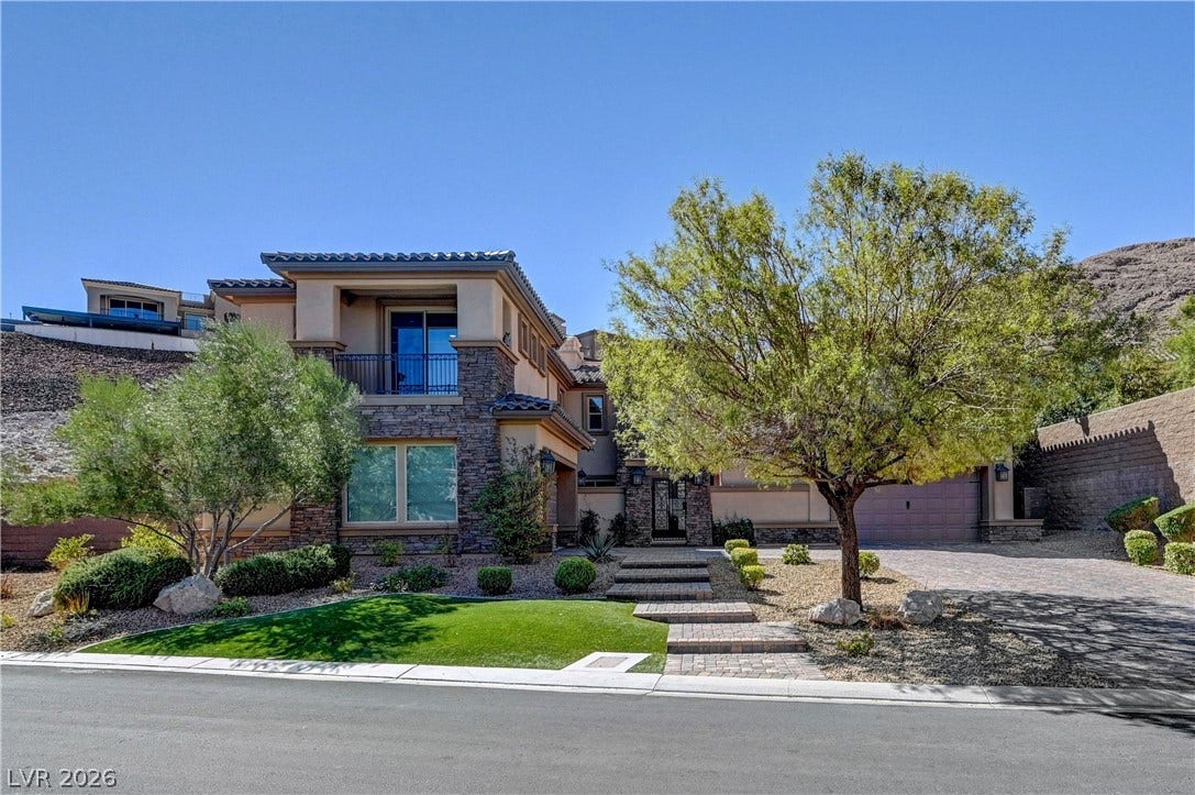 89 Olympia Chase Drive, Las Vegas, NV 89141 Exquisite stone and stucco elevation showcases multi-level design amidst manicured desert landscaping.