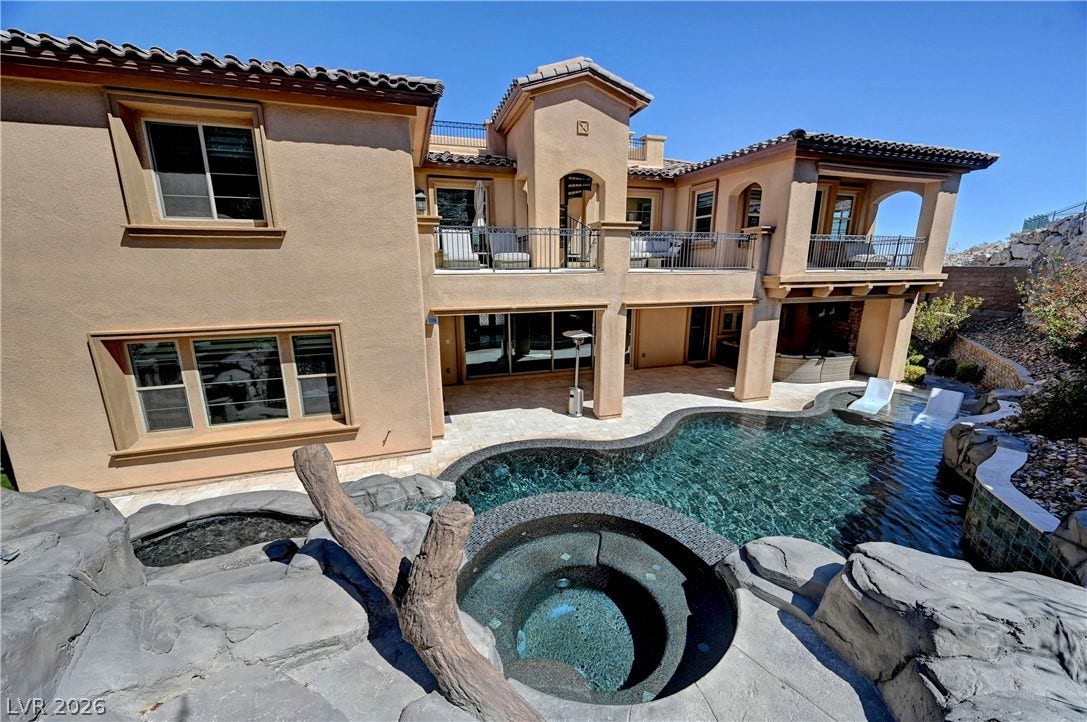 89 Olympia Chase Drive, Las Vegas, NV 89141 A custom resort-style swimming pool and integrated spa frame this multi-level stucco estate.