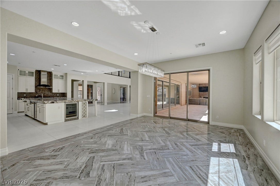 89 Olympia Chase Drive, Las Vegas, NV 89141 Gleaming tile floors in a herringbone pattern ground this airy, open-concept dining space.