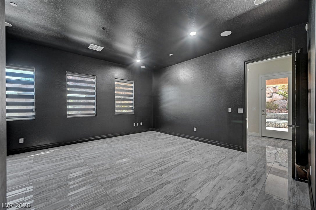89 Olympia Chase Drive, Las Vegas, NV 89141 Polished tile flooring and dark walls create a dramatic foundation in this versatile interior space.