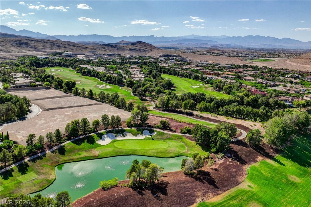 89 Olympia Chase Drive, Las Vegas, NV 89141 Lush golf course greens and a scenic water hazard highlight this elevated desert community view.