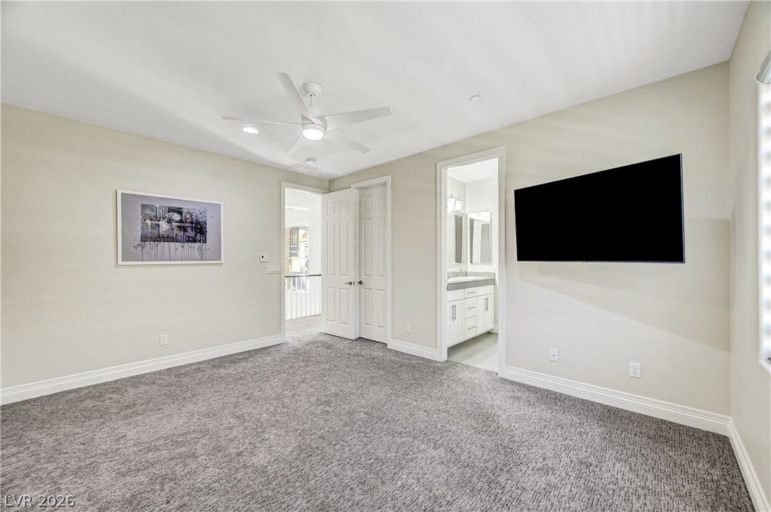 89 Olympia Chase Drive, Las Vegas, NV 89141 Soft carpeting pairs with recessed lighting to create a comfortable, inviting secondary bedroom layout.