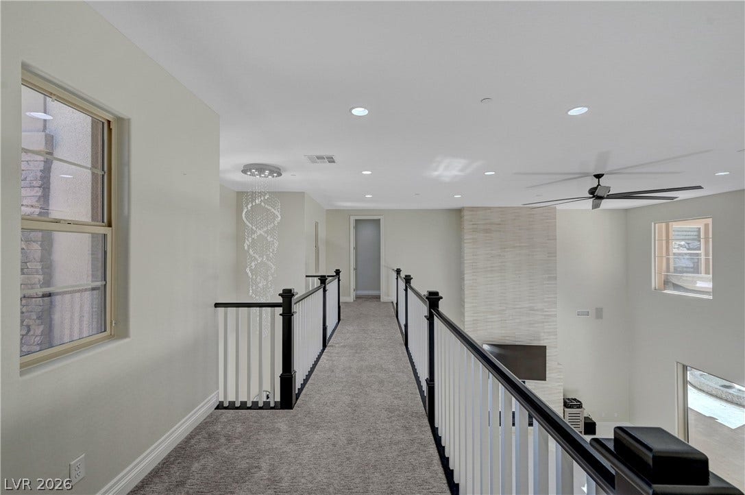 89 Olympia Chase Drive, Las Vegas, NV 89141 An elevated carpeted walkway overlooks the spacious lower level below.