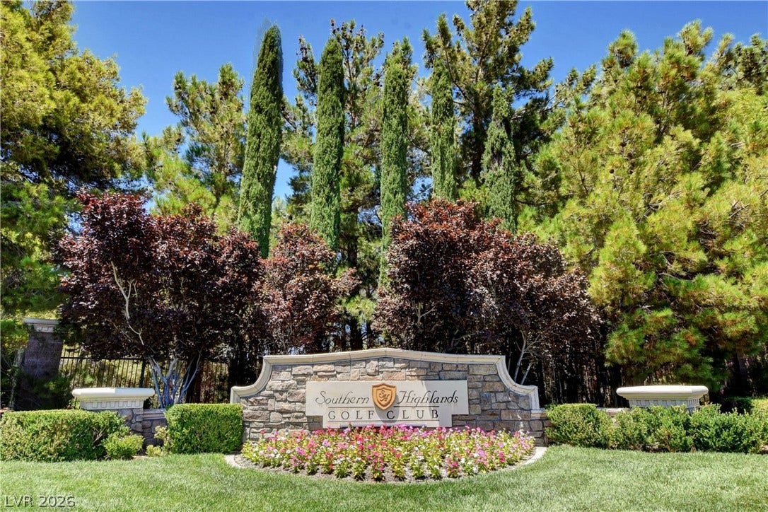 89 Olympia Chase Drive, Las Vegas, NV 89141 Mature trees and professional landscaping frame the stone entry sign to the neighborhood.