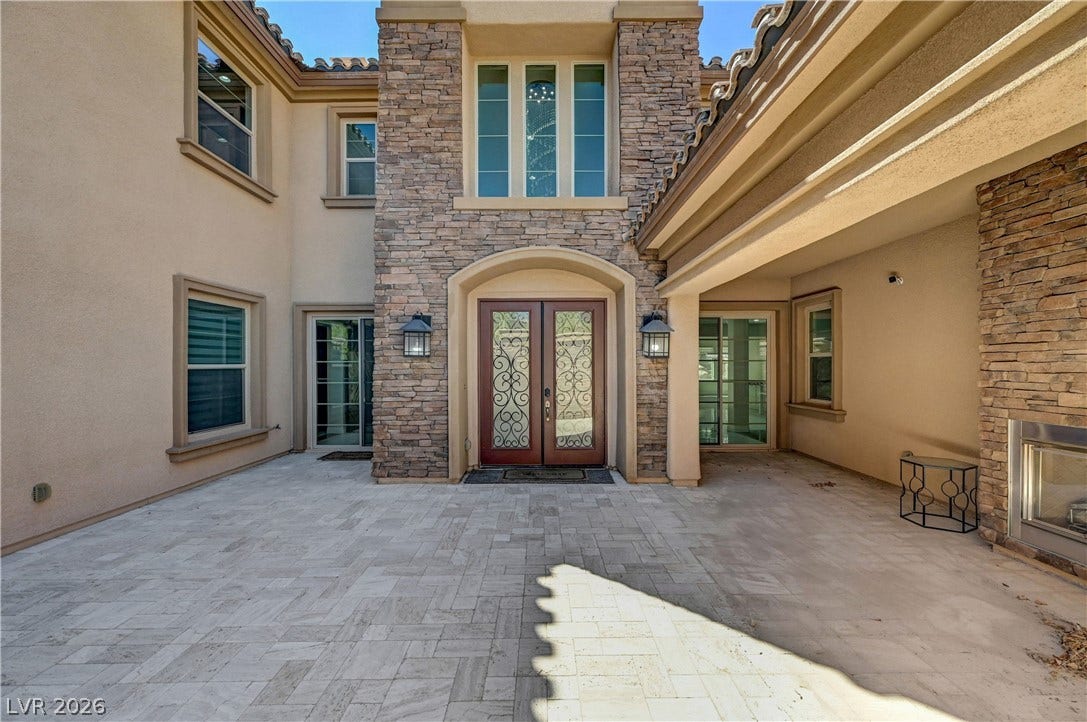 89 Olympia Chase Drive, Las Vegas, NV 89141 Ornate double doors welcome guests into a grand entryway flanked by stone accents and pavers.