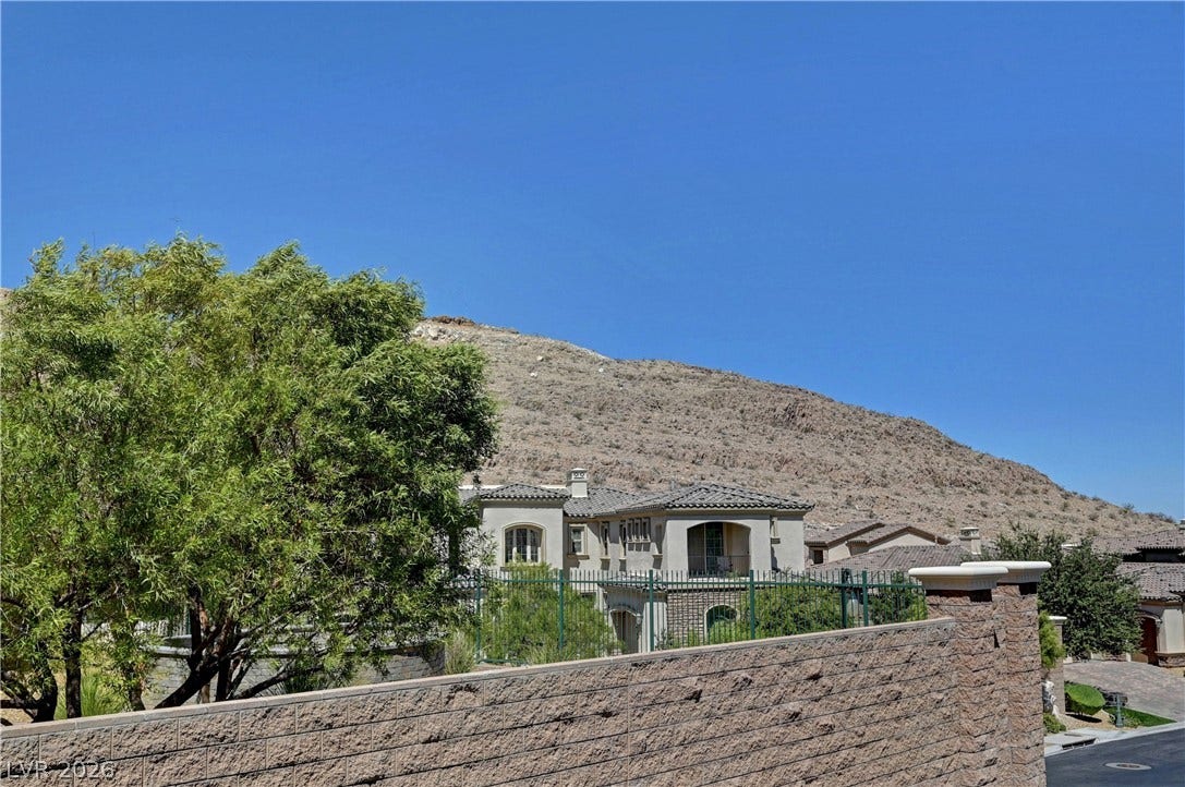 89 Olympia Chase Drive, Las Vegas, NV 89141 Dramatic mountain views frame this multi-level stucco estate surrounded by private stone walls.