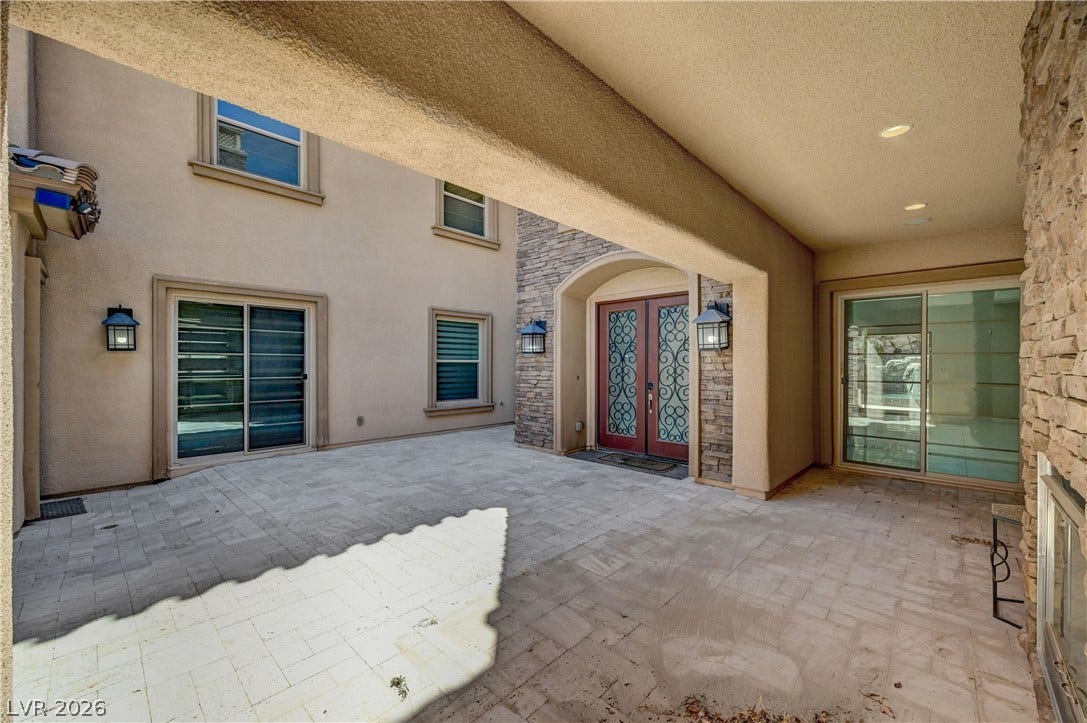 89 Olympia Chase Drive, Las Vegas, NV 89141 Stone accents and paved flooring define this welcoming entrance courtyard.
