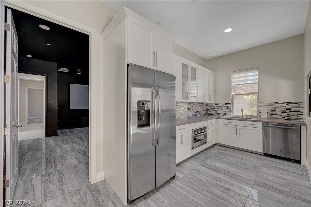 89 Olympia Chase Drive, Las Vegas, NV 89141 Gleaming stone tile flooring sweeps through this modern kitchen space with sleek cabinetry.
