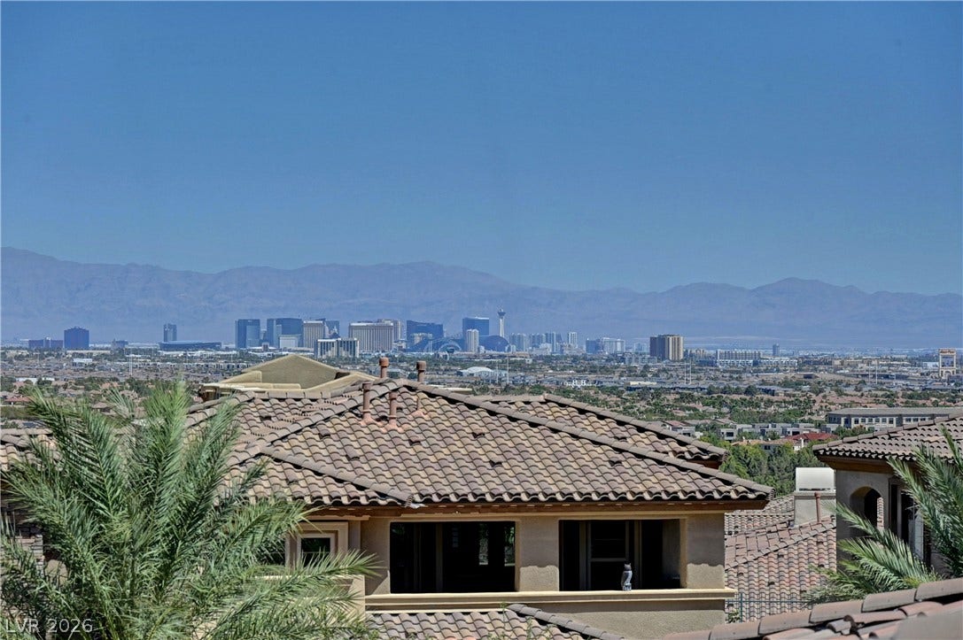 89 Olympia Chase Drive, Las Vegas, NV 89141 Distant city skyline views sit framed by mountain ridges under clear blue skies.