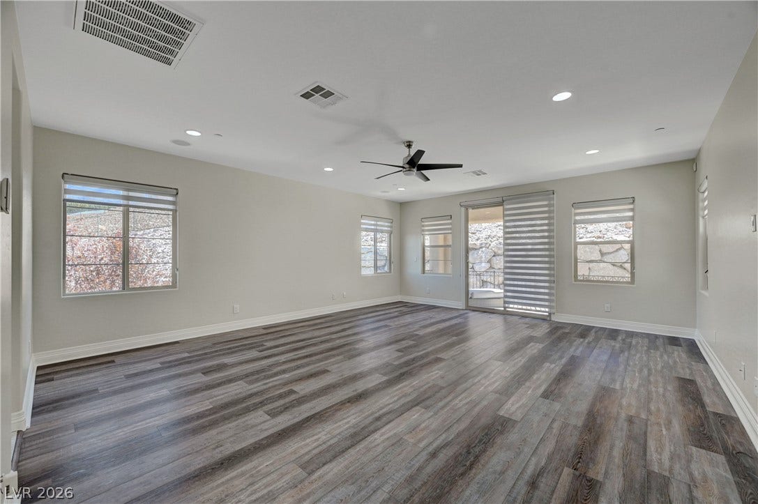 89 Olympia Chase Drive, Las Vegas, NV 89141 Gleaming wood-look floors anchor a versatile layout with sliding glass door access outside.