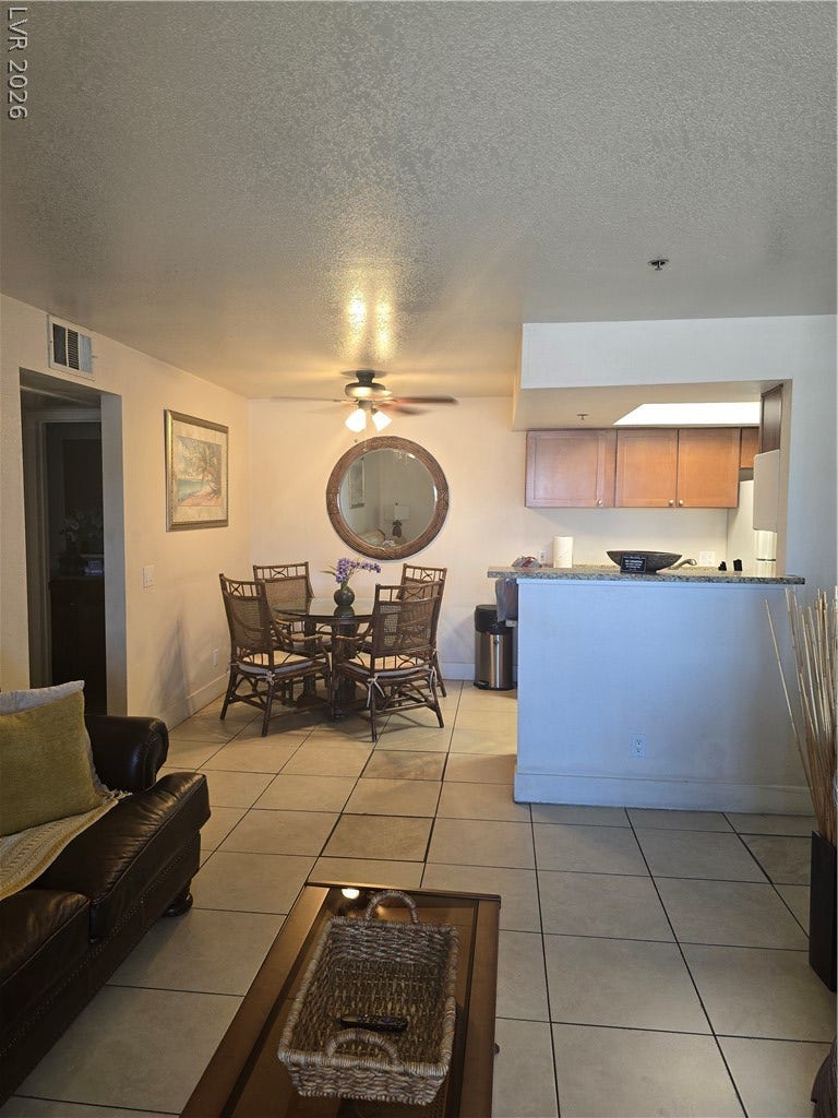 Tiled flooring and a practical pass-through connect the dining space to the kitchen.