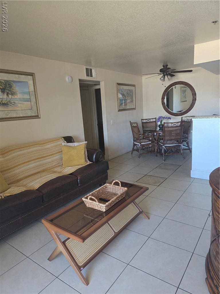 Ceramic tile floors and a soaring vaulted ceiling define this open-concept main living area.