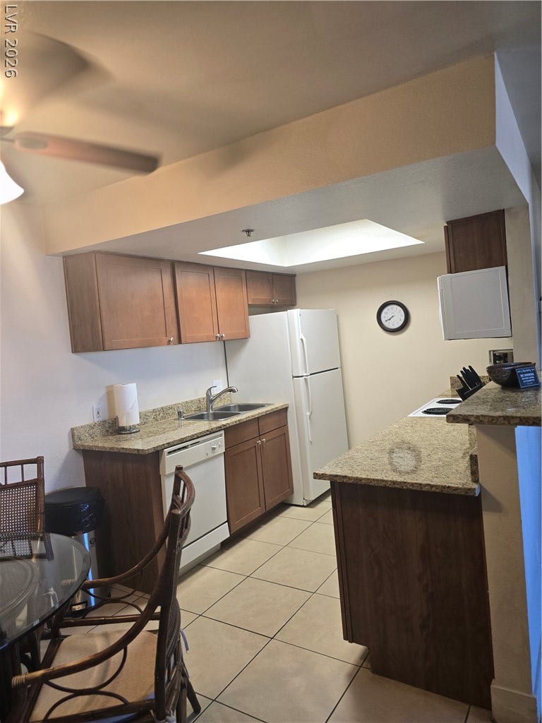 Warm wood cabinetry and granite countertops frame this efficient kitchen layout.