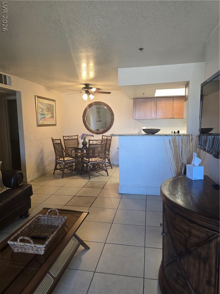 An open floor plan connects the tiled living space directly to the kitchen area.