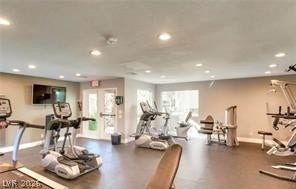 Recessed lighting illuminates this fully equipped fitness space featuring durable solid flooring.