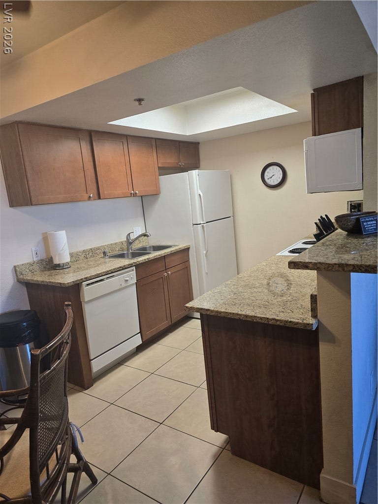 Granite countertops and warm wood cabinetry define this functional kitchen workspace.