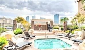 An inviting outdoor spa area framed by classic stone landscaping under a dramatic city skyline.