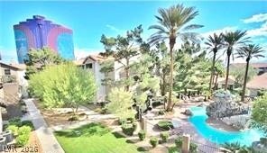 Lush tropical landscaping surrounds a sparkling resort-style pool under clear blue skies.