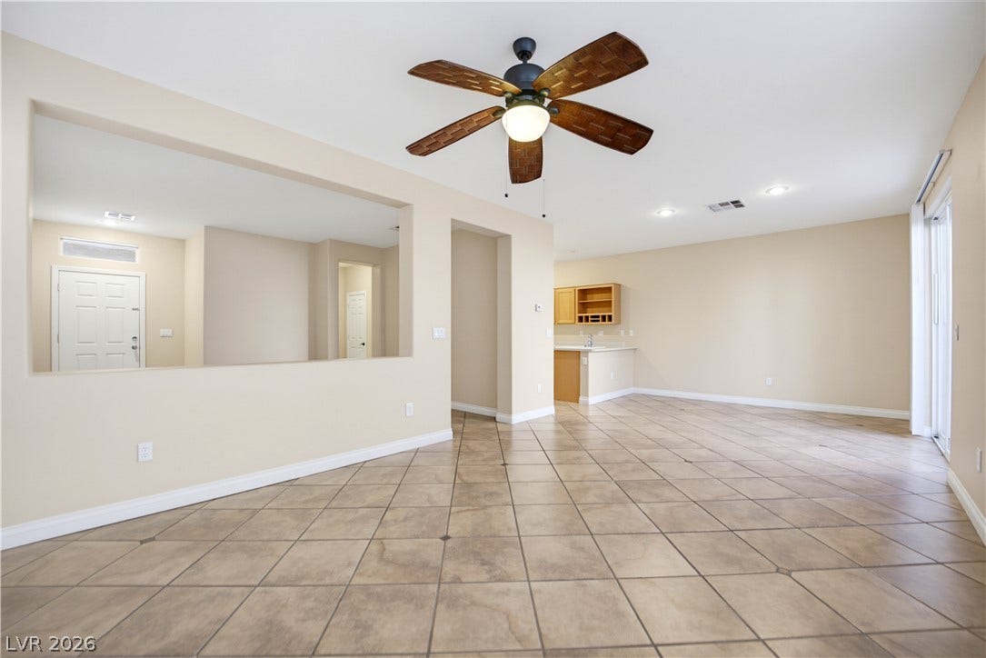 An open floorplan flows seamlessly across tile flooring under recessed lighting.