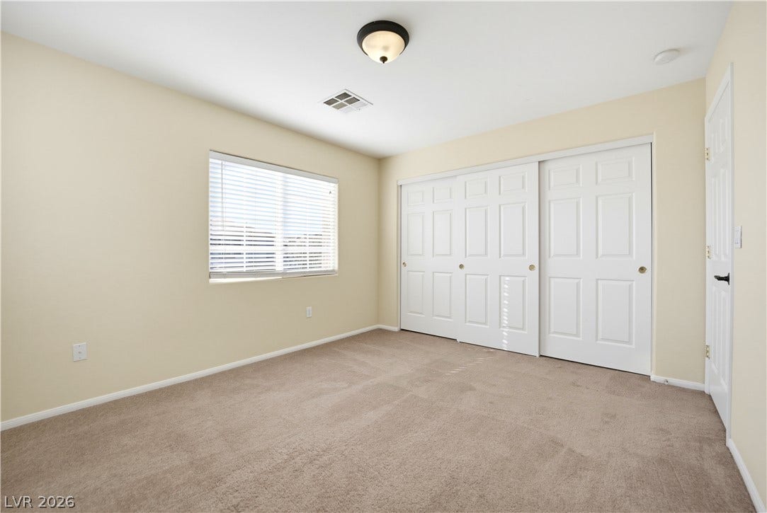 Soft carpeting pairs with a multi-panel sliding closet in this comfortable bedroom space.