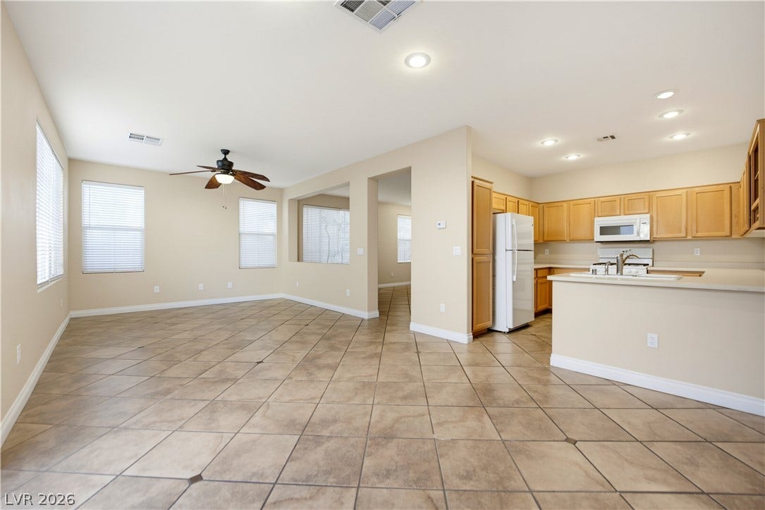 Ceramic tile floors and recessed lighting anchor this open-concept layout connecting the main living areas.