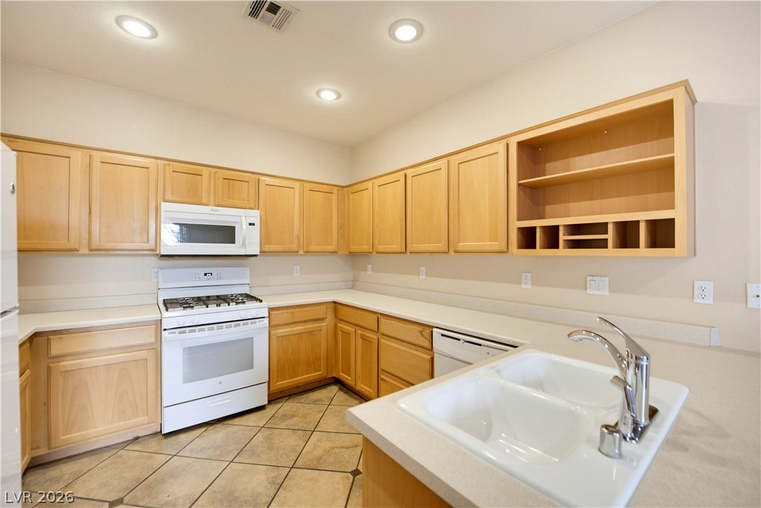 Ample wooden cabinetry and solid countertops define this highly functional culinary space.