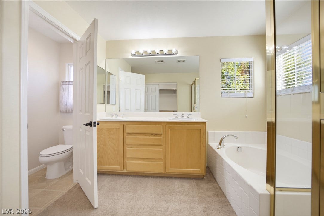 An integrated soaking tub and double vanity define this functional bathroom layout.