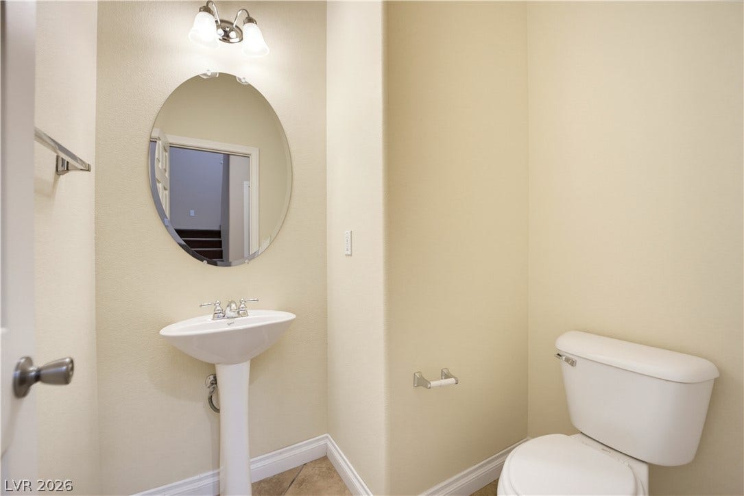 A classic pedestal sink and neat tile floors define this functional powder room.