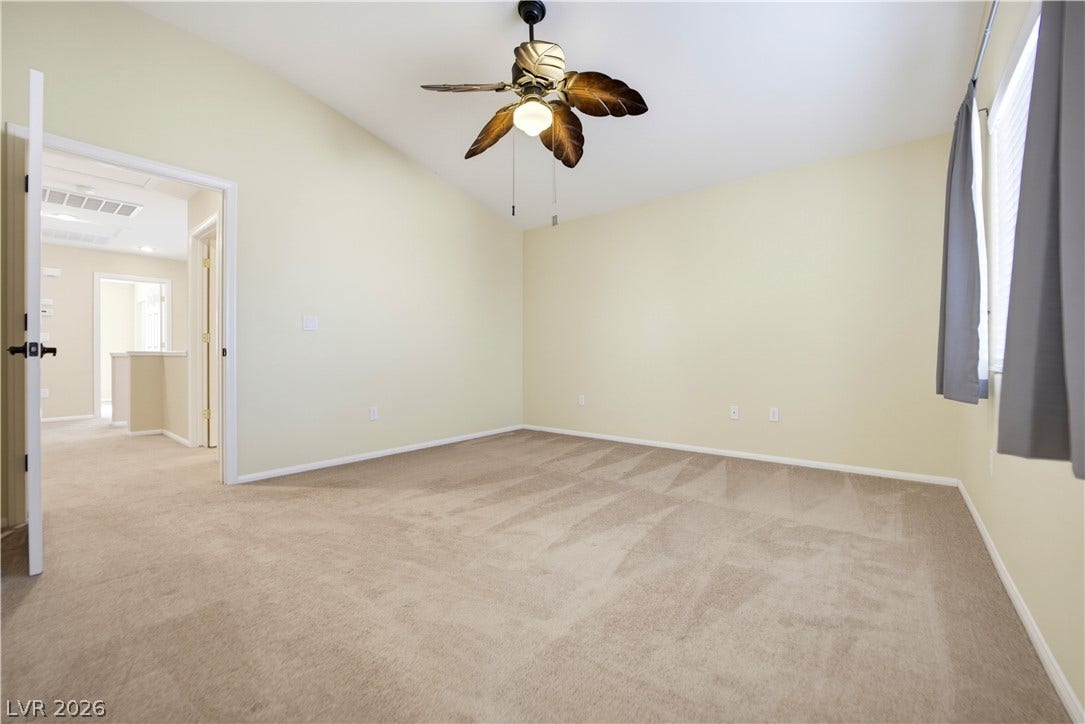 Vaulted ceilings and soft carpeting create a peaceful atmosphere in this spacious bedroom.